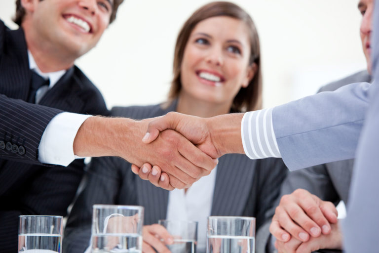 Smiling business people closing a deal /solutions/supply-chain-management/consultation/